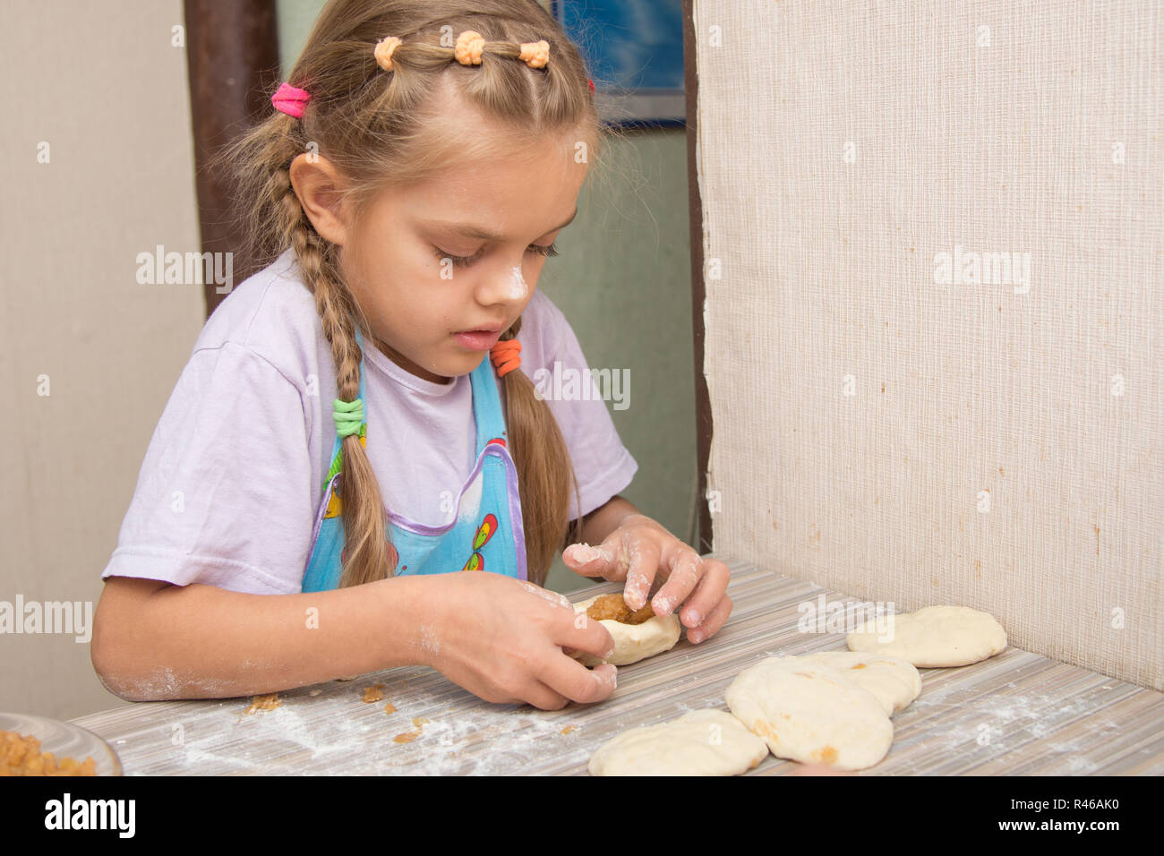 Sechs Jahre altes Mädchen Konzentration formt Kuchen mit Kohl Stockfoto