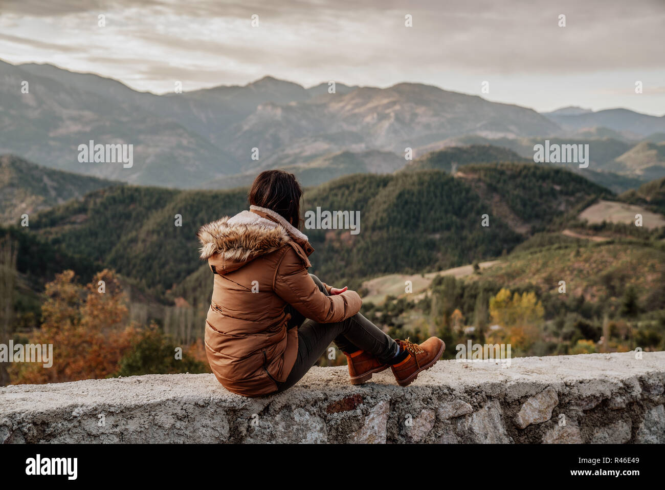 Frau traveler schaut am Rand der Klippe der Berge im Hintergrund. Stockfoto
