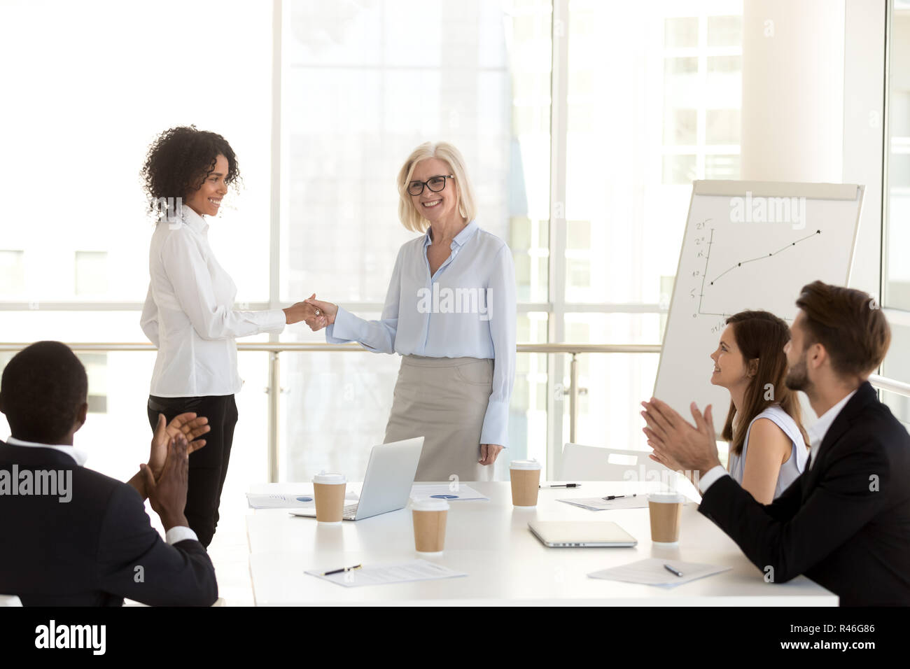 Lächelnd reifen Chef handshaking afrikanischen Mitarbeiter gratulieren. Stockfoto