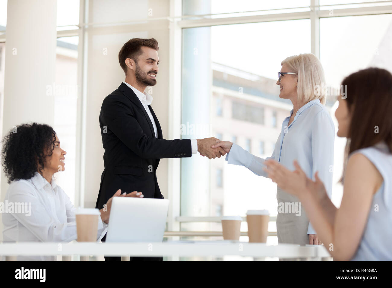 Glücklich im Alter von Executive handshaking erfolgreicher Mitarbeiter congratulat Stockfoto