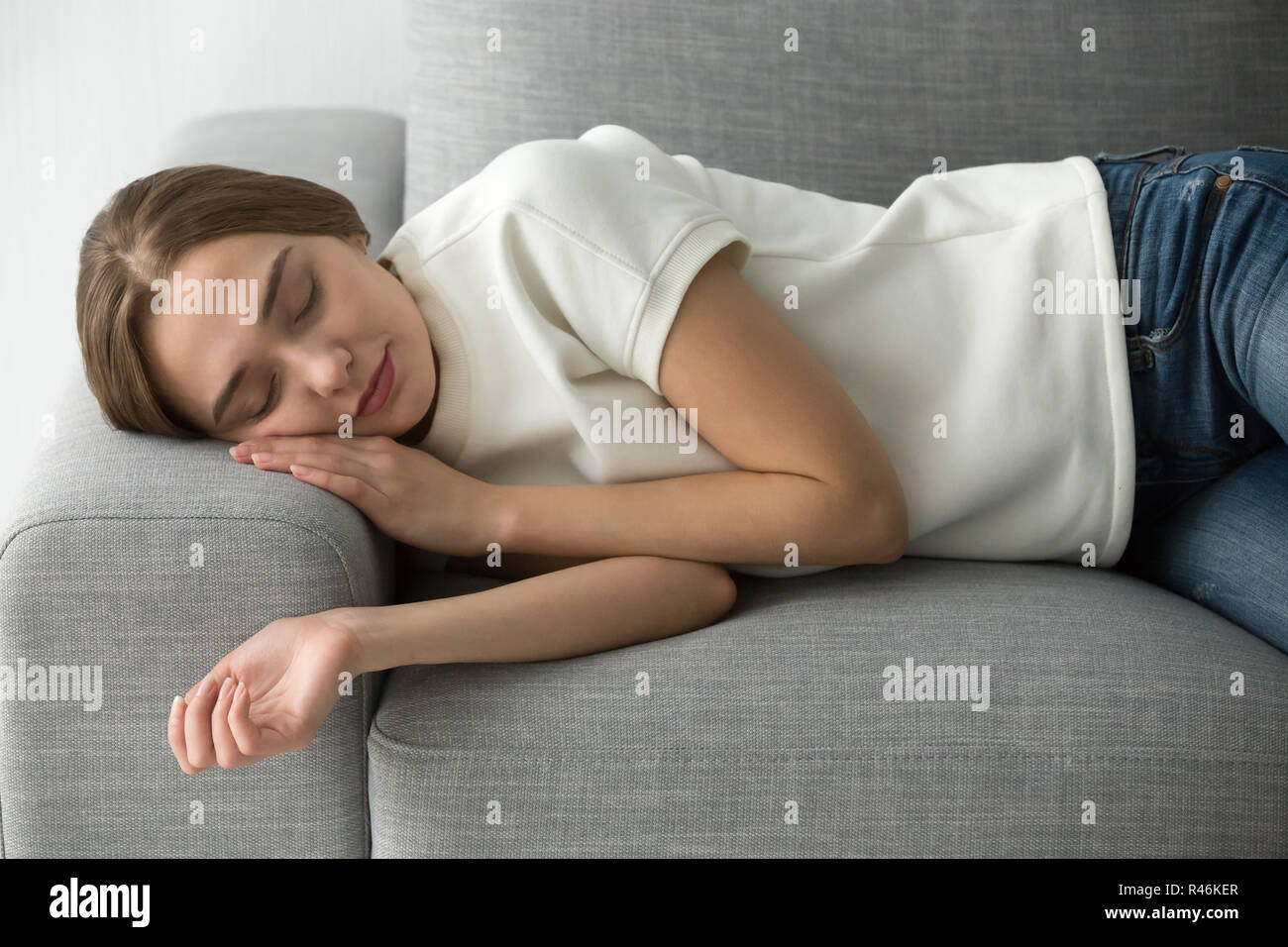 Attraktive Frau schlafen auf komfortables, weiches Sofa Stockfoto