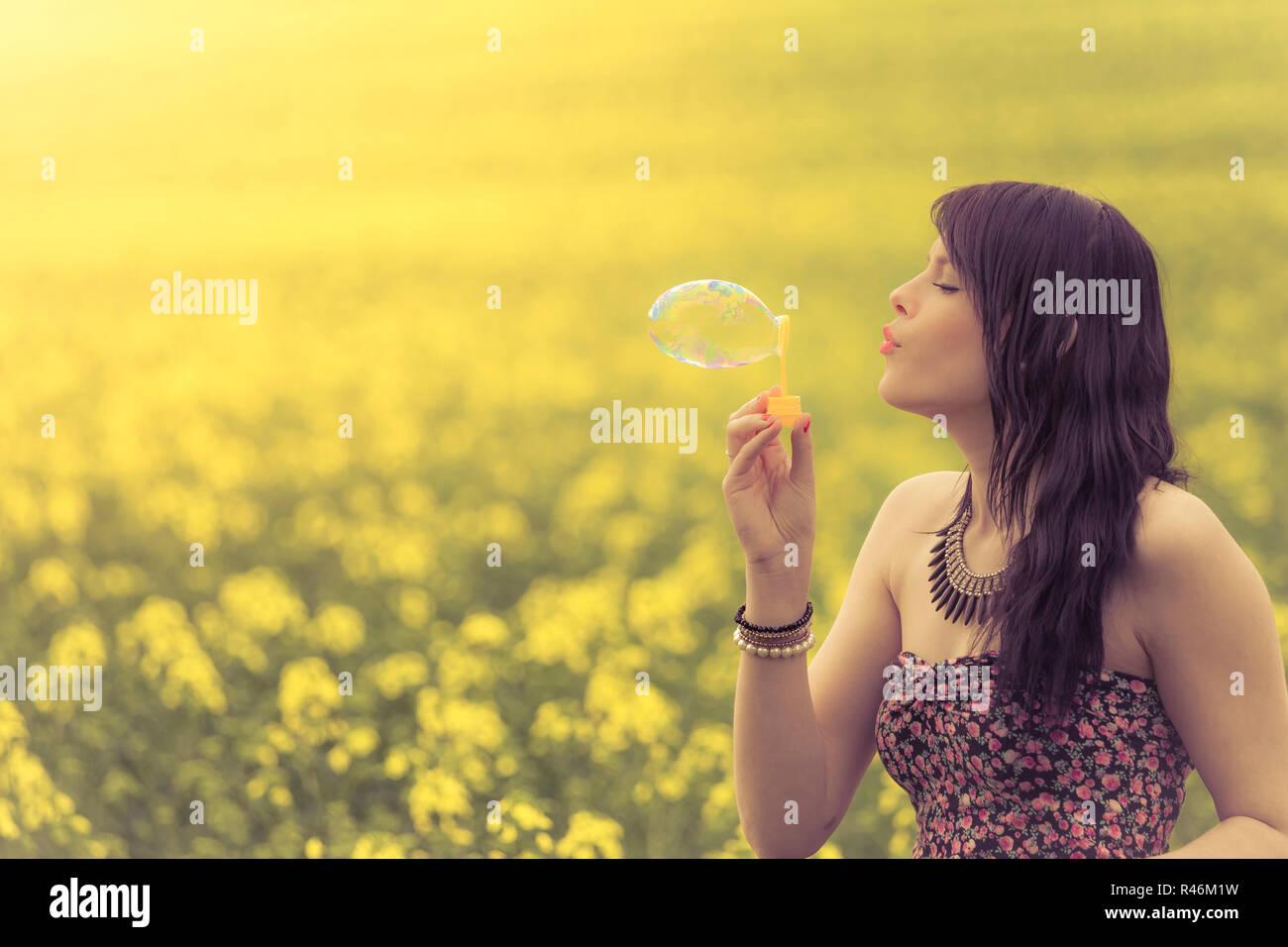 Schöne Frau eine Seifenblase in Gelb sommer wiese Blasen Stockfoto
