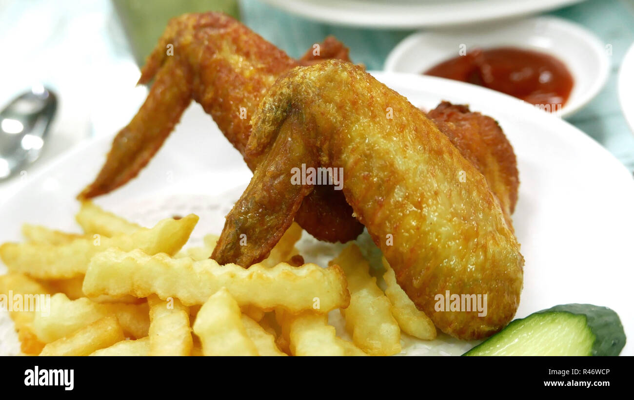 Zwei Chicken Wings und Pommes frites auf dem weißen Teller Stockfoto