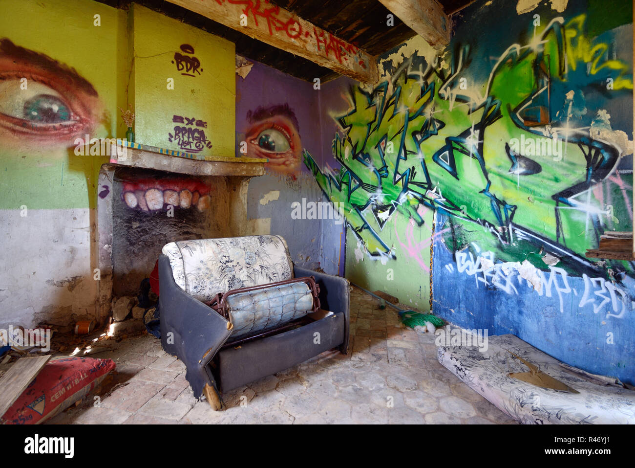 Graffiti Bedeckte Wände, Müll Mit Verstreuten Böden und Zerbrochenes Sofa in Squat Interior des Verlassenen Hauses Provence France Stockfoto