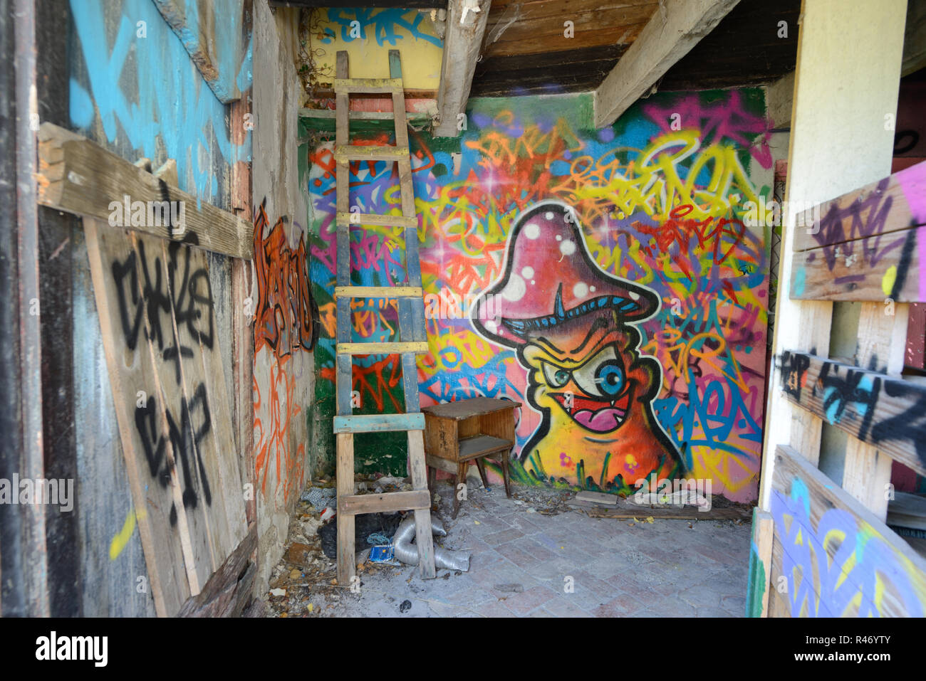 Graffiti an den Wänden, Hausgemachte wackeligen Leiter & Magic Mushroom Design in die Hocke, Interieur des verlassenen Haus Frankreich Stockfoto