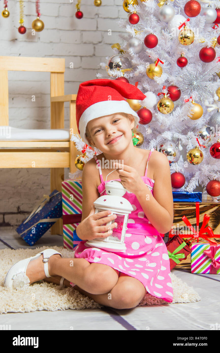 Glückliches Mädchen, eine Kerze in der Hand und sitzen an den Weihnachtsbäumen Stockfoto