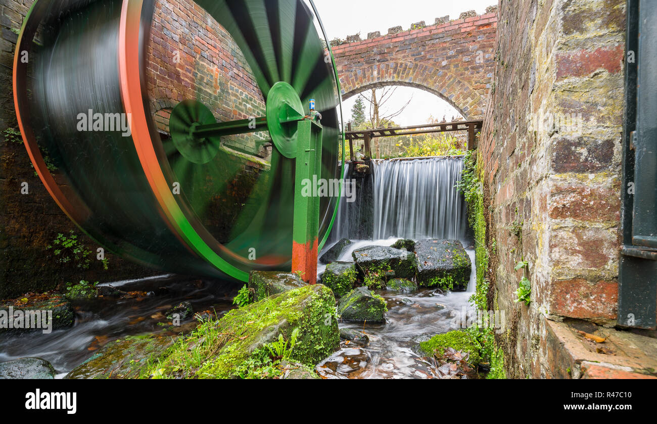 Landschaft Erfassen eines sich bewegenden traditionelle Wassermühle Rad von Wasserfällen im Hintergrund geliefert, auf einem kalten Herbst morgen in Thüringen. Stockfoto