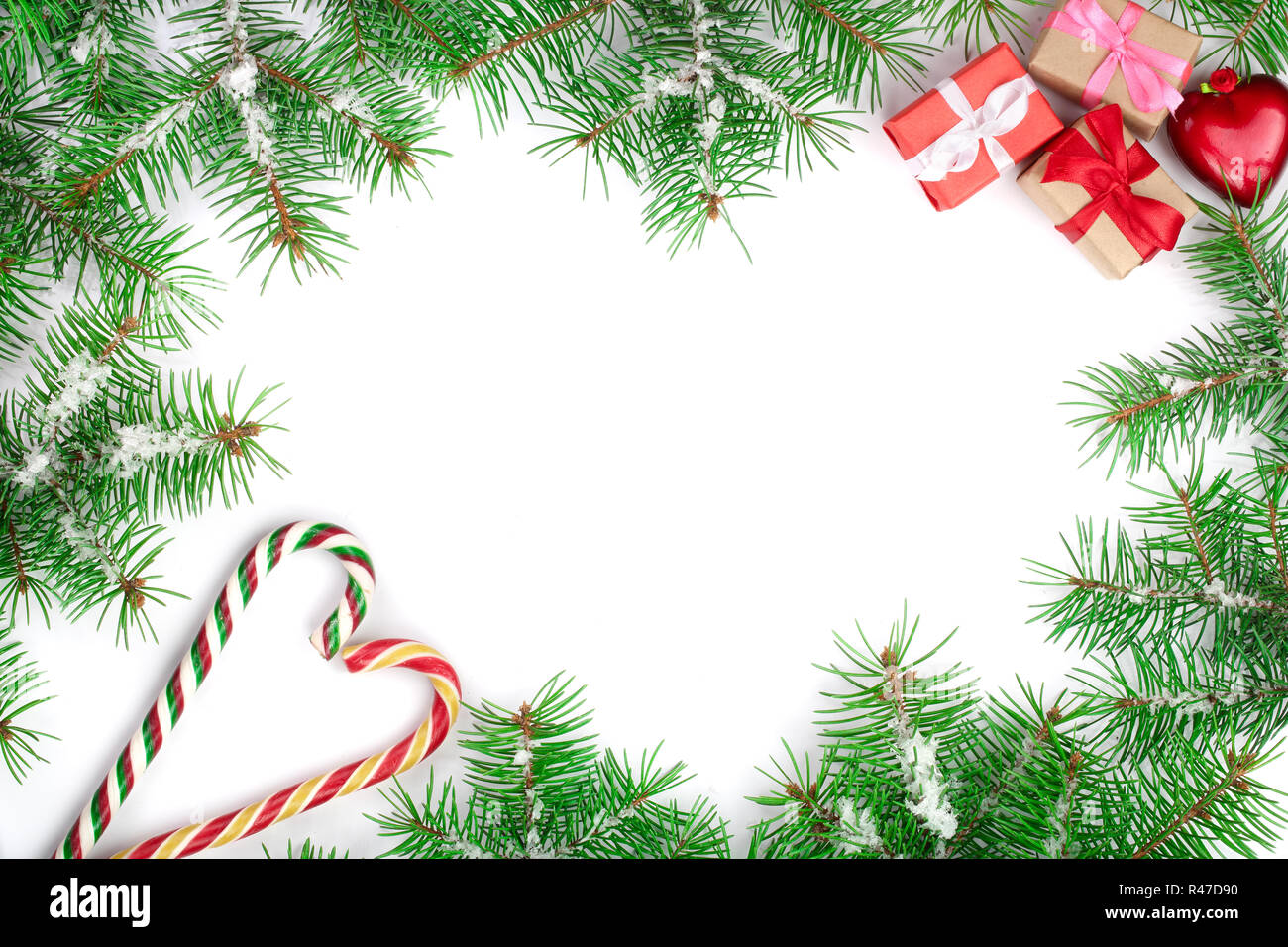 Weihnachten Rahmen der Fir Tree Branch mit Zuckerstangen und Schnee auf weißem Hintergrund mit Kopie Platz für Ihren Text isoliert Stockfoto