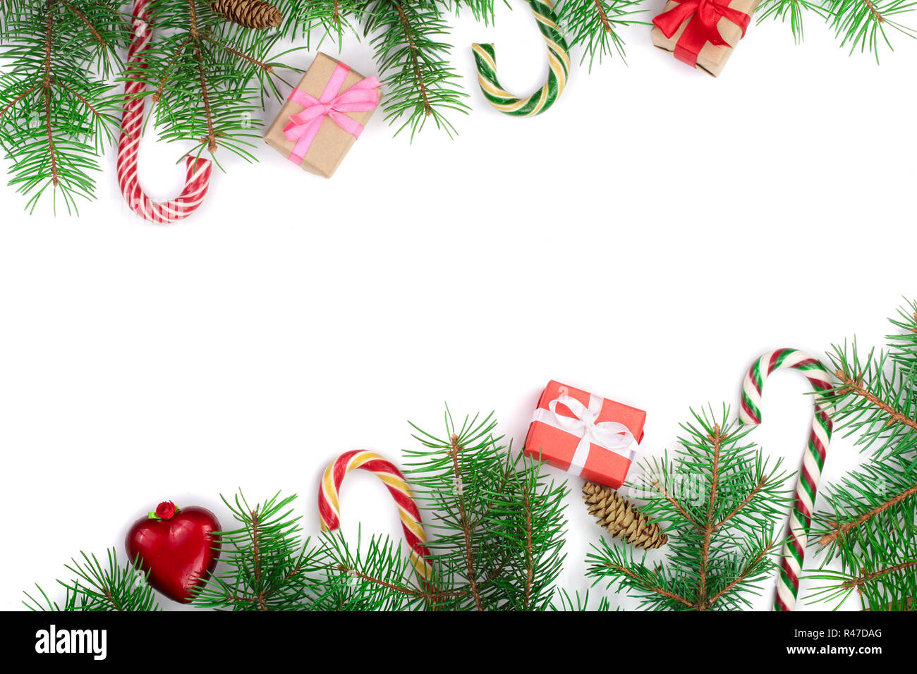 Weihnachten Rahmen der Fir Tree Branch mit Zuckerstangen und Boxen auf weißem Hintergrund mit Kopie Platz für Ihren Text isoliert Stockfoto
