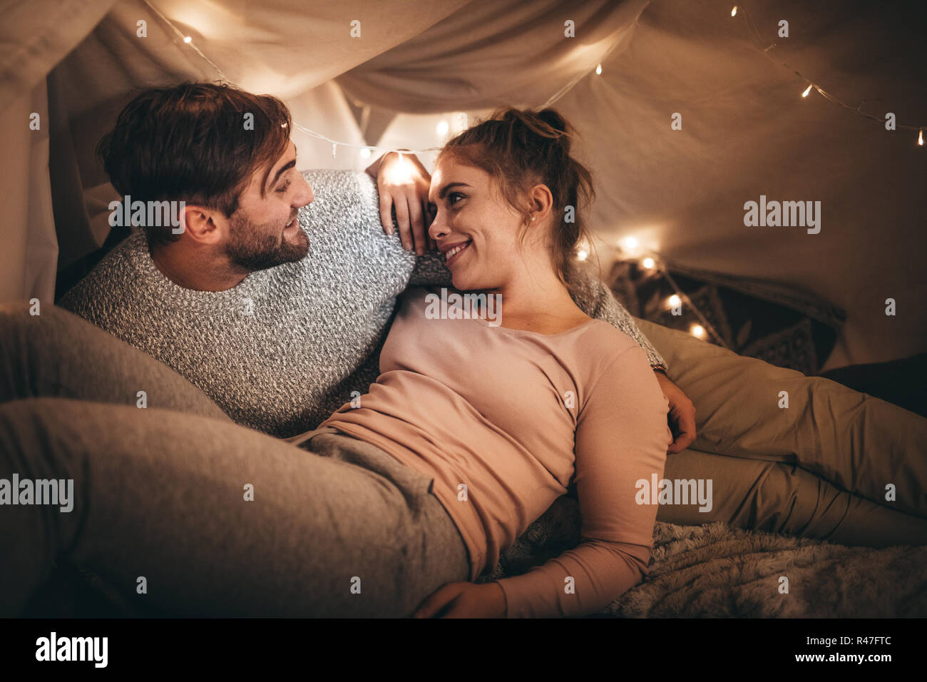 Glücklich der Mann und die Frau liegend auf Bett sprechen, während Sie sich gegenseitig suchen. Romantisches Paar verbringen Zeit miteinander reden auf dem Bett in der Nacht mit winzigen b Stockfoto