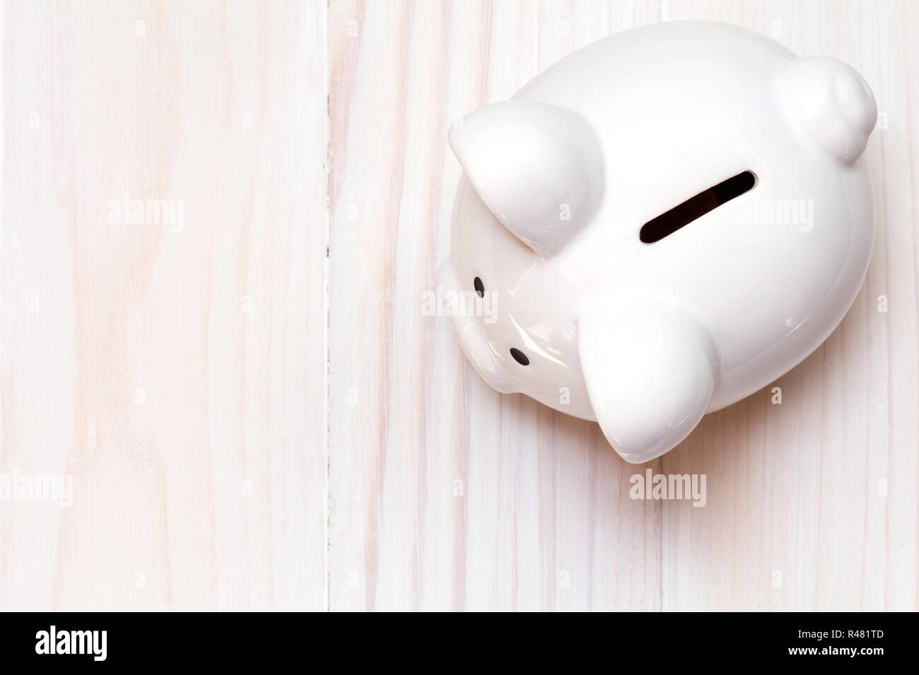 Sparschwein auf dem weißen Holz- Hintergrund Stockfoto