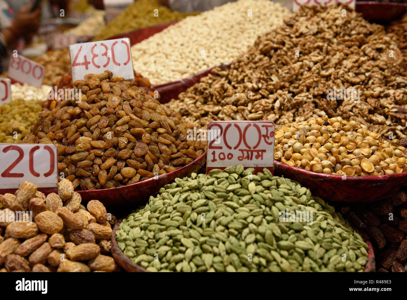 Mehrere Behälter mit einer Auswahl an frischen Früchten, Nüssen und Gewürzen in der gewürzmarkt von Old Delhi, Indien. Stockfoto