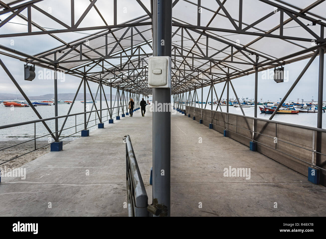 Geteilte Ansicht einer Zement Pier mit zwei Menschen zu Fuß auf einen grauen Tag Stockfoto