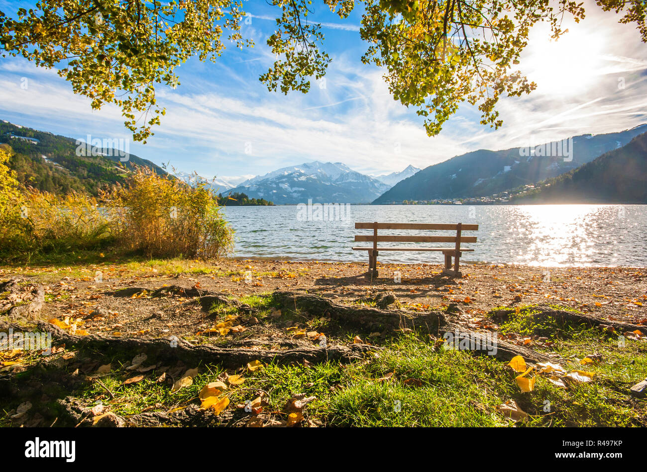 Schönen Herbst Szene mit Parkbank und Bergsee in den Alpen, Zell am See, Salzburger Land, Österreich Stockfoto