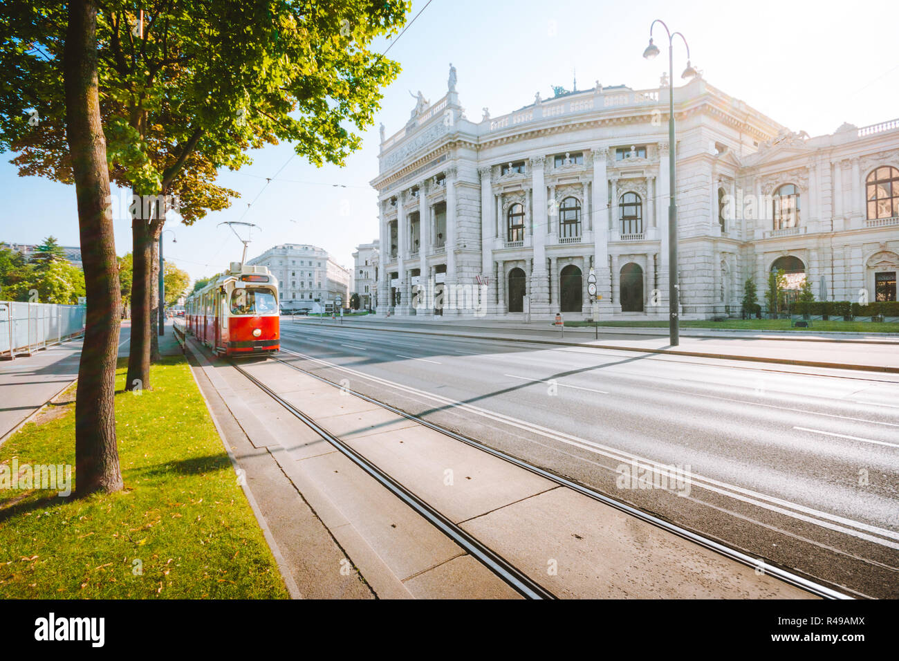 Berühmte Wiener Ringstraße mit historischen Burgtheater (Imperial Court Theatre) und traditionellen roten elektrische Straßenbahn bei Sonnenaufgang mit Retro Vintage Instagram Stockfoto