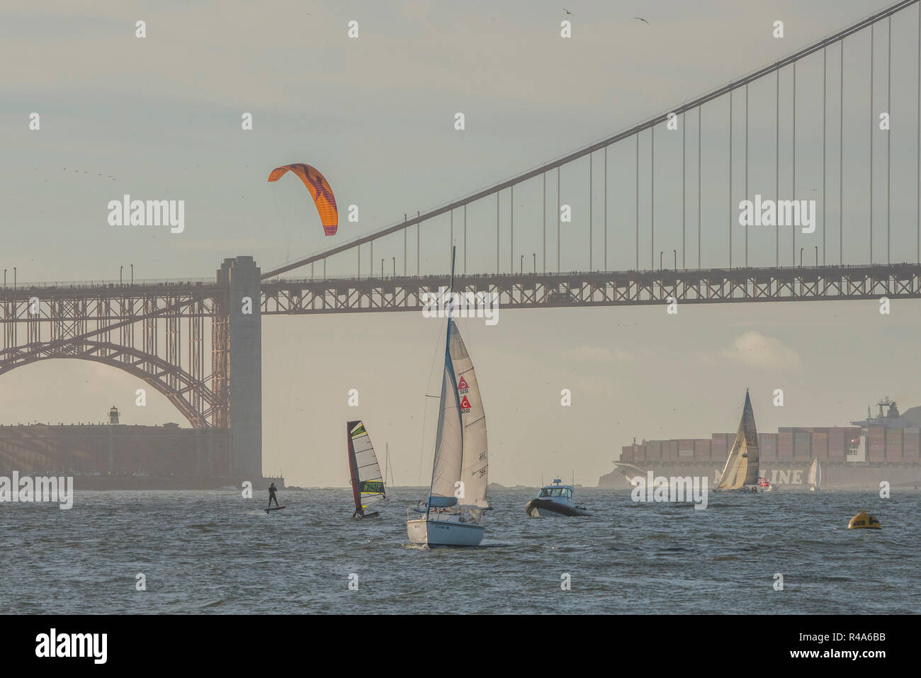 Ein Kitesurfer, Windsurfer, Segelboot, Motorboot und Fracht alle durch die Bucht von San Francisco mit der Golden Gate Bridge. Stockfoto