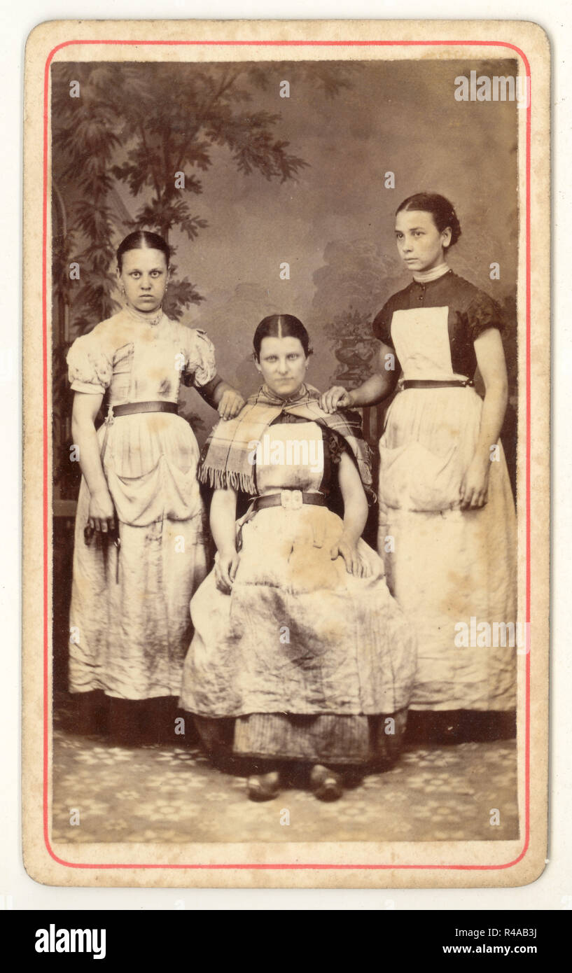 Original und seltene viktorianische Carte de Visite (CDV) 1800 Studioportrait von einer Gruppe von 3 schlecht aussehenden Lancashire Baumwollmühlenmädchen, die Clogs und schmutzige Schürzen trugen, aus den Studios von Albert Parker, Blackpool, Lancashire, England, um 1870 Stockfoto