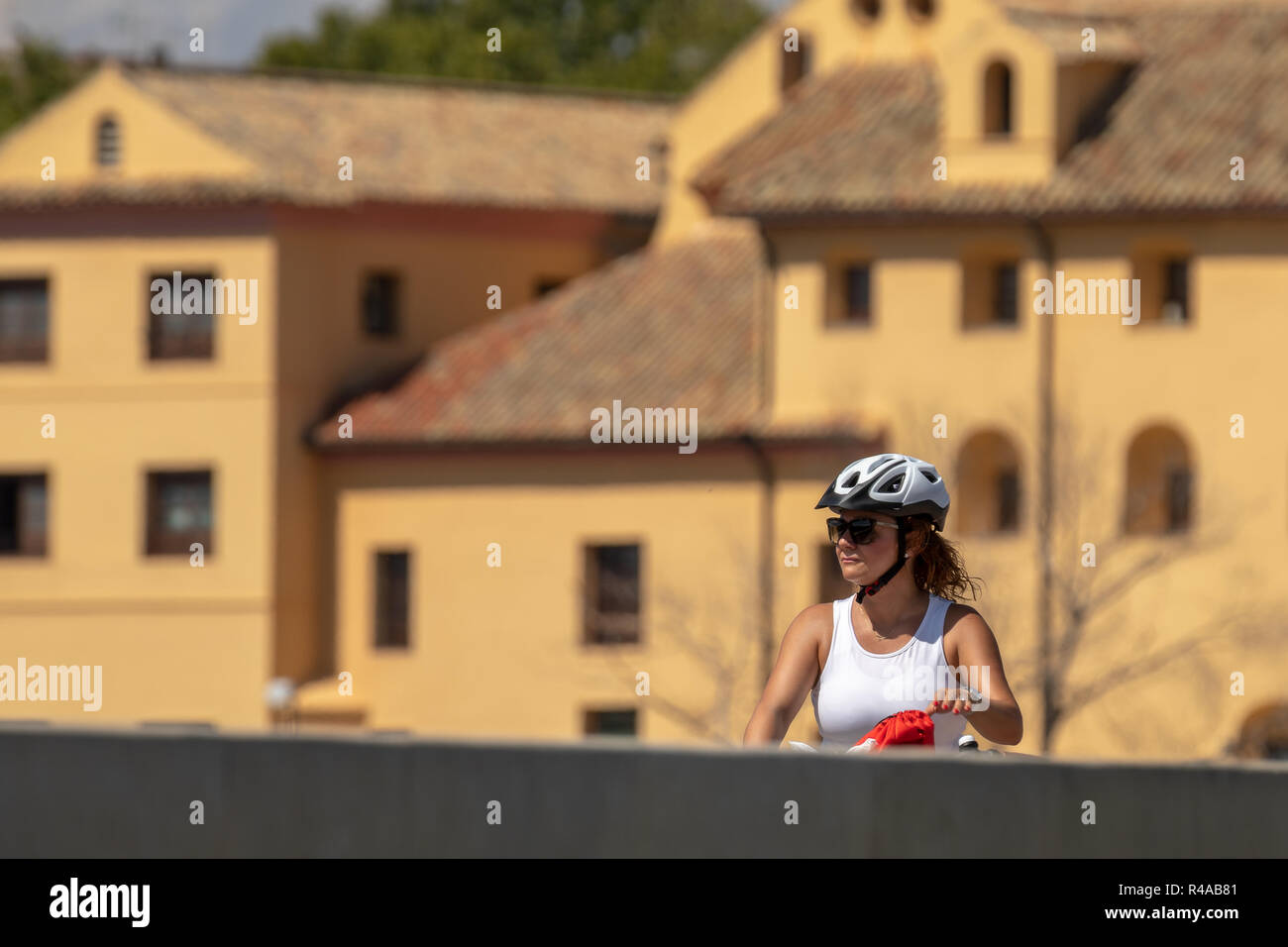 Frau Radfahrer mit Helm reiten durch ein touristischer Ort. Stockfoto