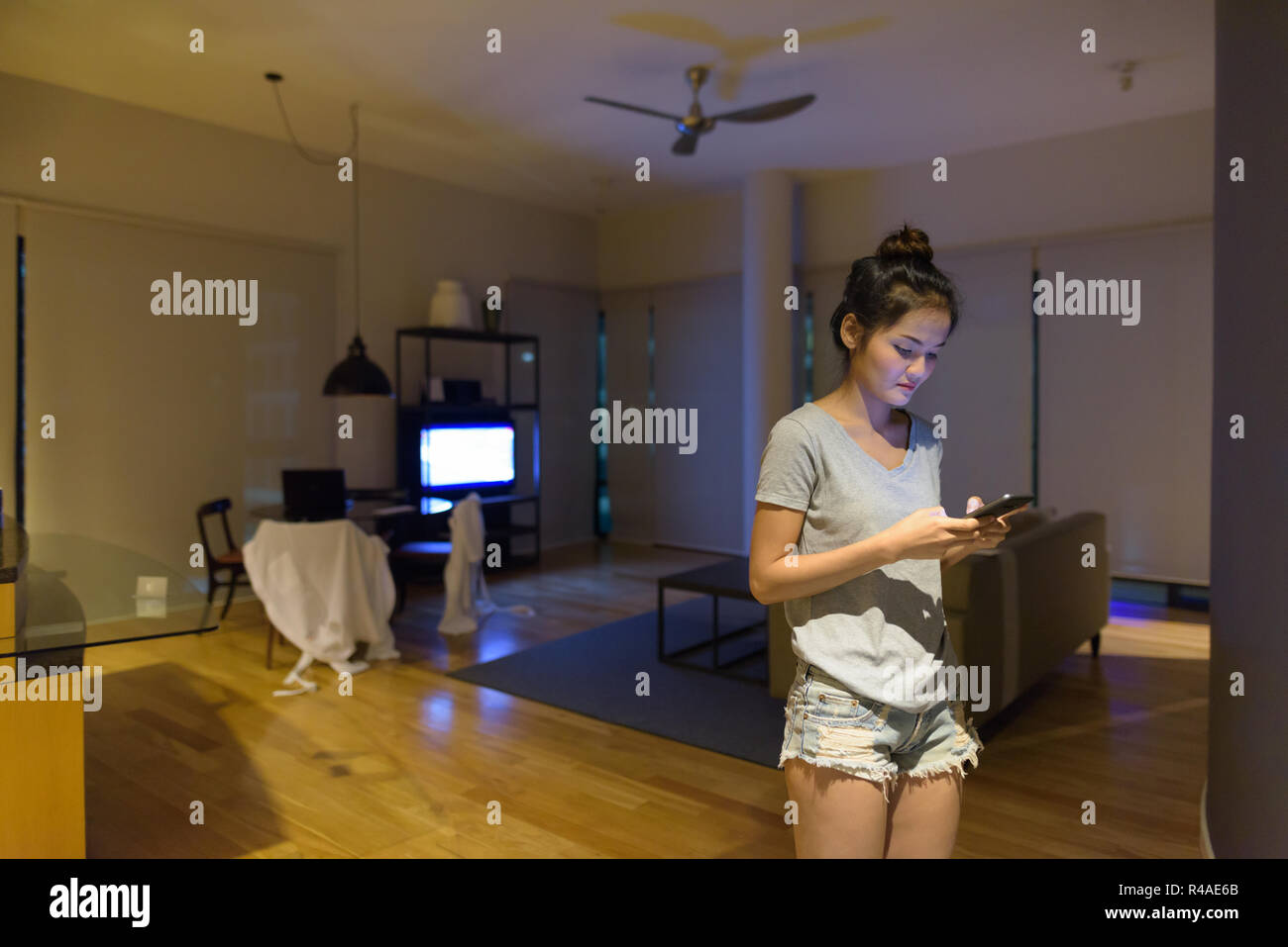 Junge schöne asiatische Frau entspannen im Wohnzimmer Stockfoto