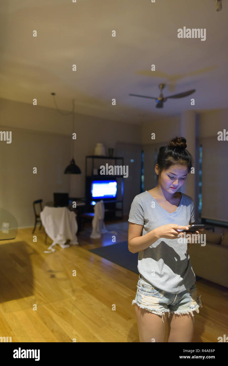 Junge schöne asiatische Frau entspannen im Wohnzimmer Stockfoto