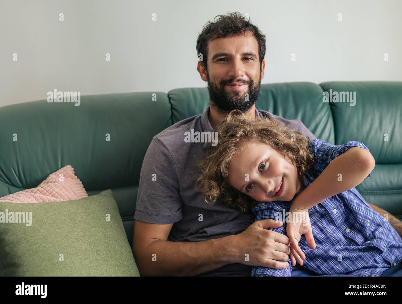 Lächelnd Vater und Sohn auf dem Sofa zu Hause sitzen Stockfoto