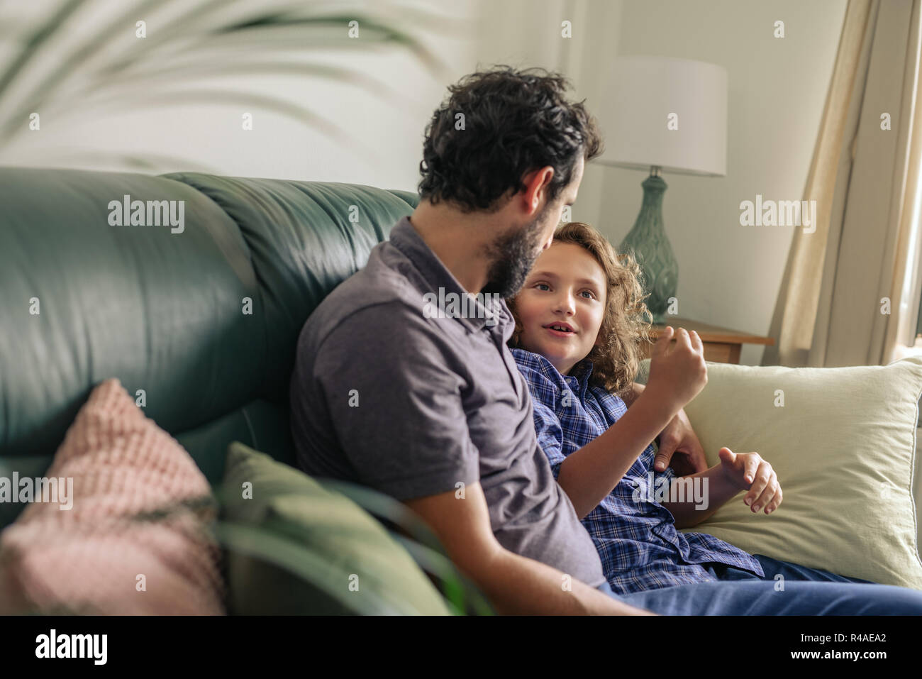 Lächelnd Vater und Sohn zusammen mit ihrem Sofa Stockfoto