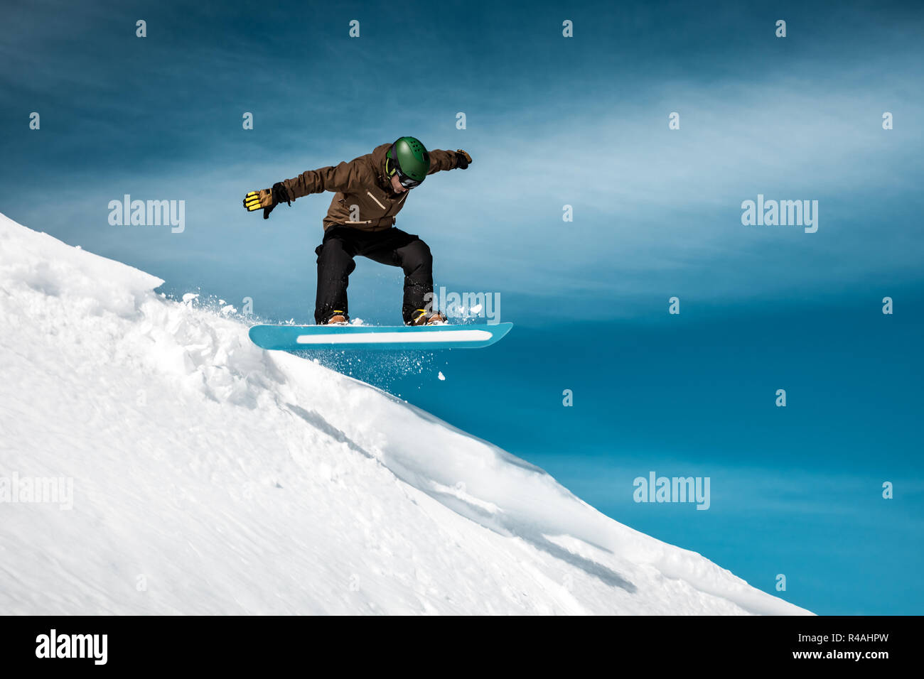 Snowboarder führt einen Trick auf der Piste in einem schneebedeckten Bergen, herrlichen sonnigen Wintertag, extreme Winter Urlaub Stockfoto