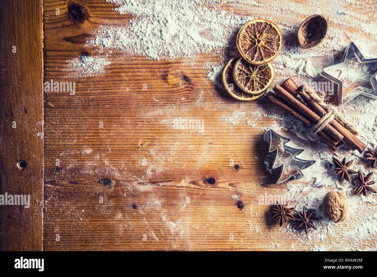 Oben auf Ansicht Bäckerei Tisch voller Weihnachten aromatischen Zutaten Sternanis Zimt Getrocknete orange Mehl Kochbuch und Ausstechformen. Stockfoto