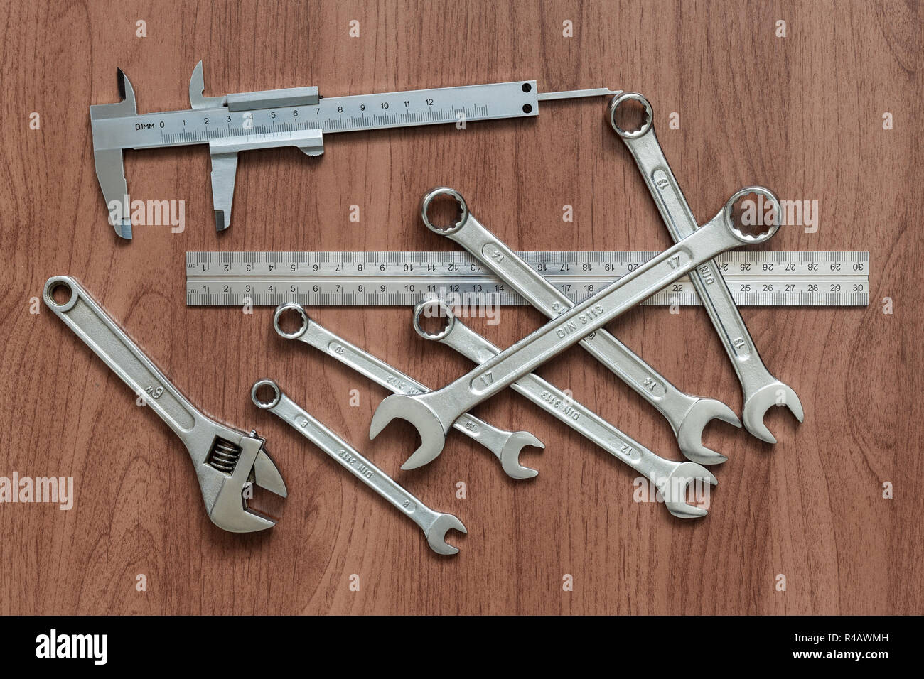 Satz Schraubenschlüssel, Bremssattel, Lineal und verstellbarer Schraubenschlüssel auf einem Holztisch. Ansicht von oben Stockfoto