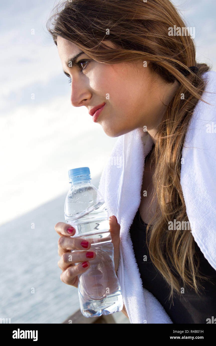 Frau trinkt Wasser nach sportlichen Aktivitäten Stockfoto