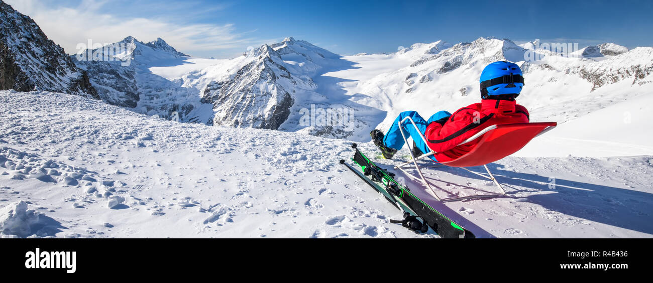 Junge glücklich attraktive Skifahrer auf der Oberseite der Berge genießen der Aussicht von Presena Gletscher, Tonale, Italien sitzen. Stockfoto