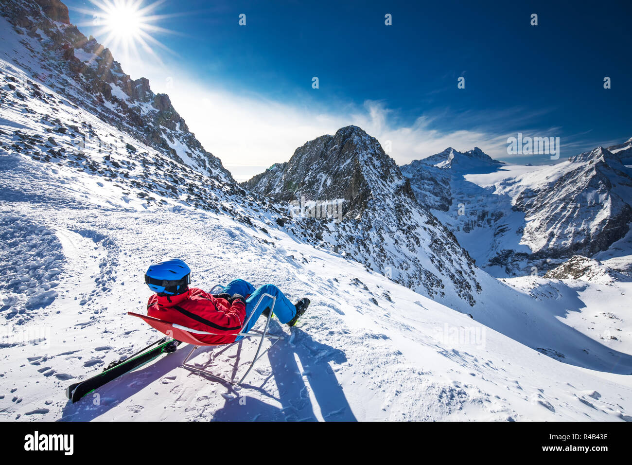 Junge glücklich attraktive Skifahrer auf der Oberseite der Berge genießen der Aussicht von Presena Gletscher, Tonale, Italien sitzen. Stockfoto