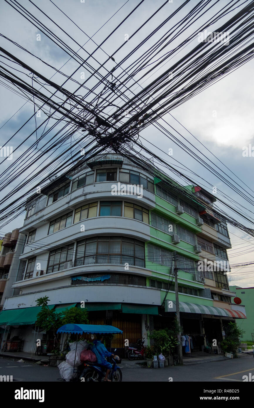 Stromleitungen dominieren die Skyline vor einem Gebäude im Art-Deco-Stil in Hat Yai, Thailand. Stockfoto