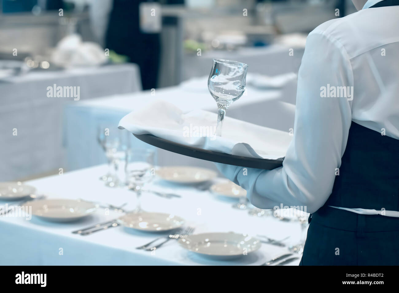 Kellnerin gekleidet in der Uniform, die eine Reihe von Weingläser Stockfoto