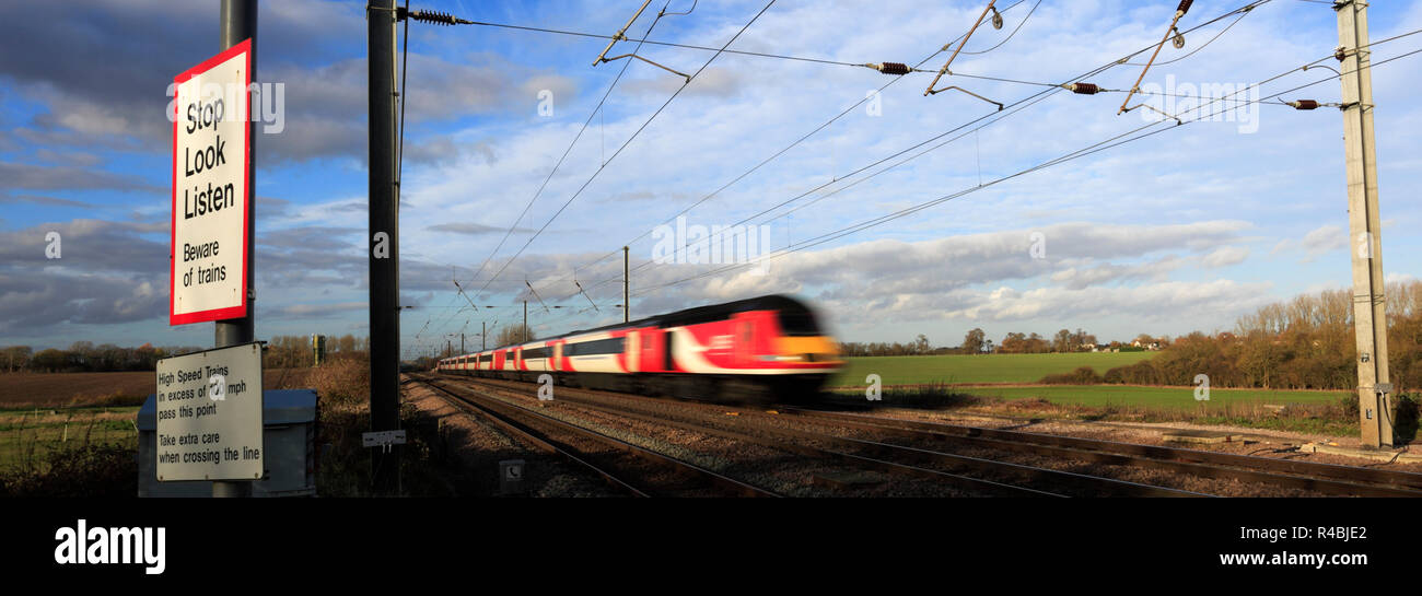 LNER Zug passiert Stop, Look, Zeichen an einem unbeschrankten Bahnübergang, Abbots Ripton Dorf, East Coast Main Line Railway, Cambridgeshire, England hören Stockfoto