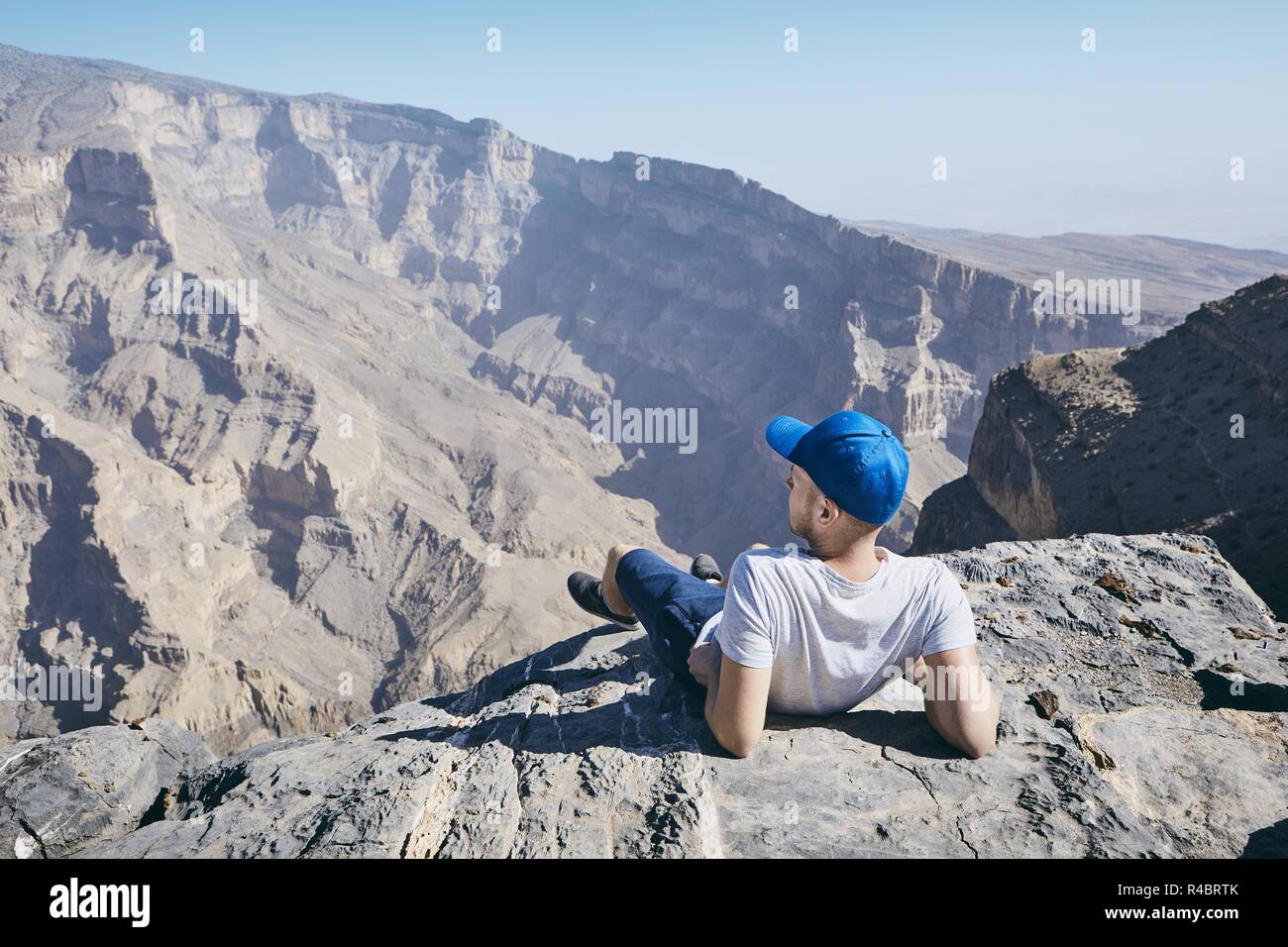 Junge touristische ruht auf den Rand der Klippe. Jebel Akhdar, Grand Canyon von Oman. Stockfoto