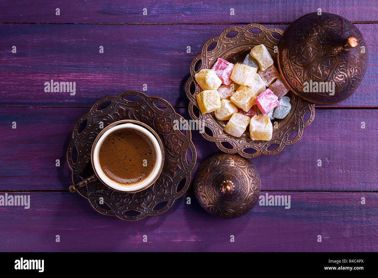 Traditionelle türkische Kaffee und Turkish Delight auf dunklem Violett Holz- Hintergrund. Flach. Stockfoto