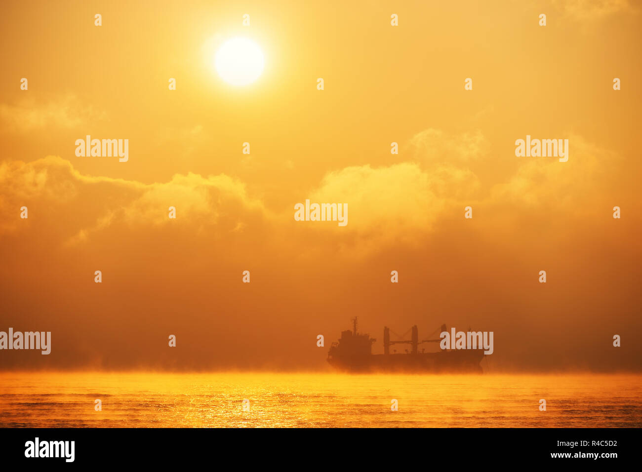 Sonnenaufgang über dem Meer mit Segeln Frachtschiff. Transport. Logistik. Versand. Stockfoto