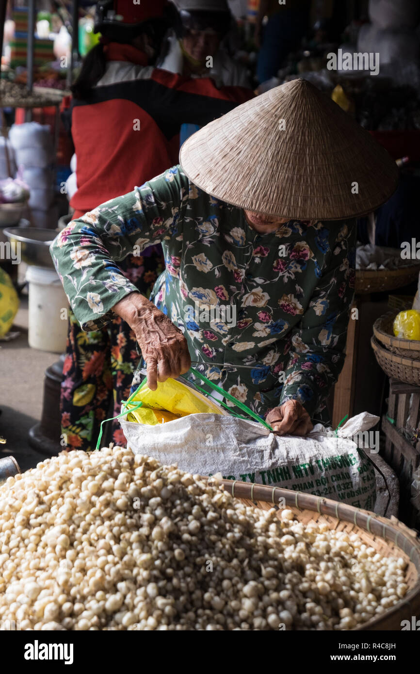 Eine ältere Frau trägt ein Reis hat bei Dong Ba Markt in Hue, Vietnam arbeiten Stockfoto