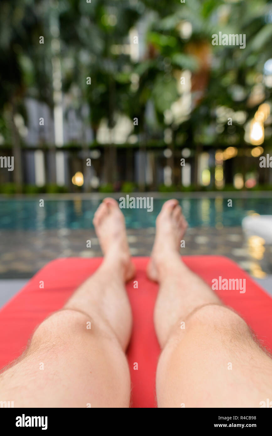 Füße junger stattlicher Mann entspannenden Swimmingpool im Hotel am Stockfoto