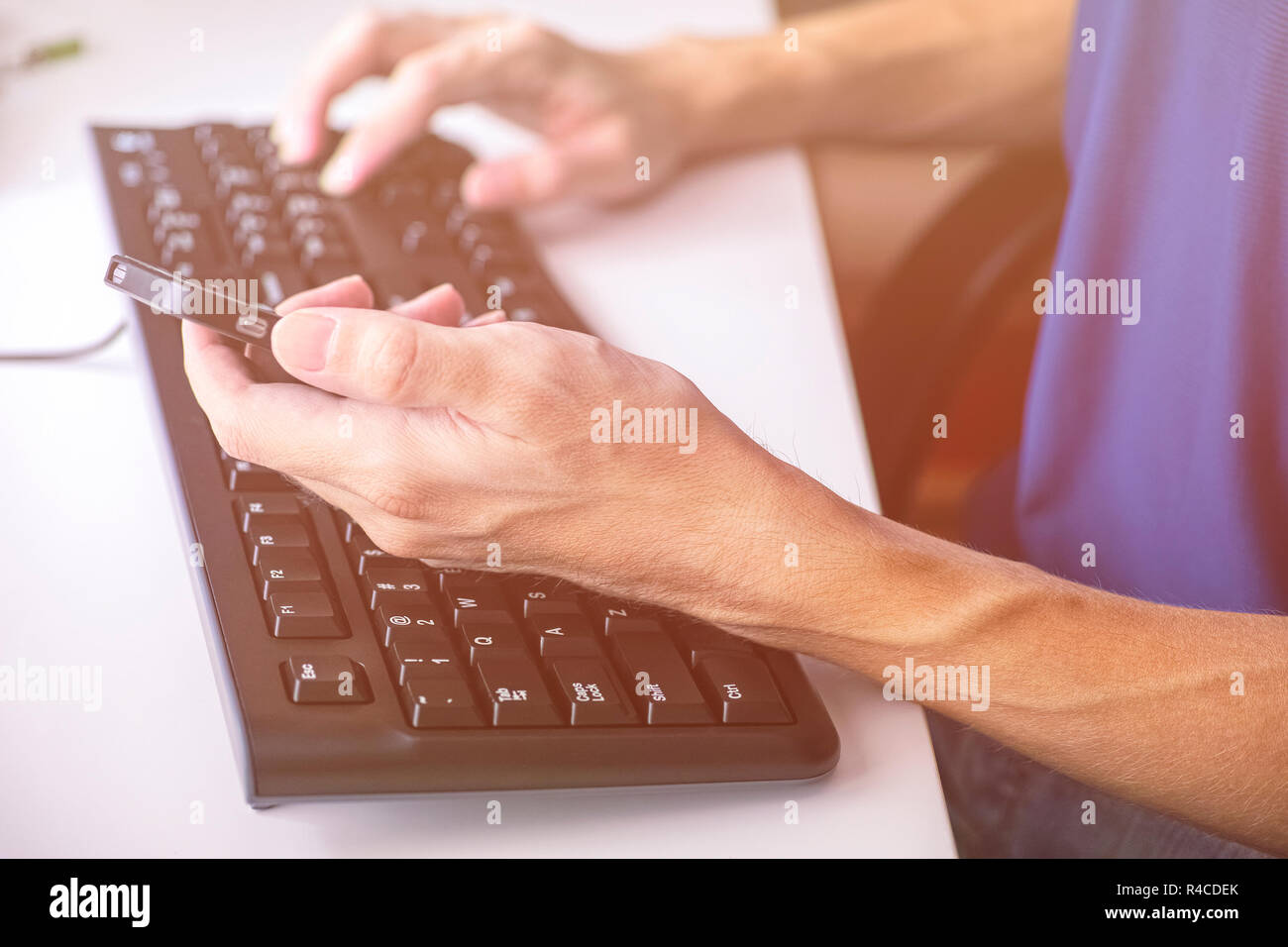 Person die Eingabe über Tastatur und Sie ihr Smartphone. Close Up. Stockfoto