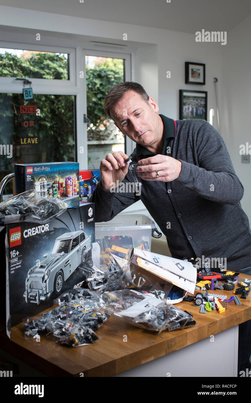 Im mittleren Alter Menschen, der Lego zu Hause in England, als Erwachsene sind die Zulassung zur Neigung zum Backstein- Phänomen, Vereinigtes Königreich. Stockfoto