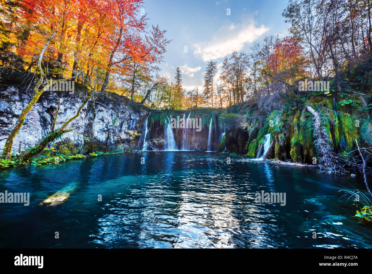 Erstaunliche Wasserfall mit reinen blauen Wasser der Plitvicer Seen. Orange Herbst Wald für den Hintergrund. Nationalpark Plitvice, Kroatien. Landschaftsfotografie Stockfoto