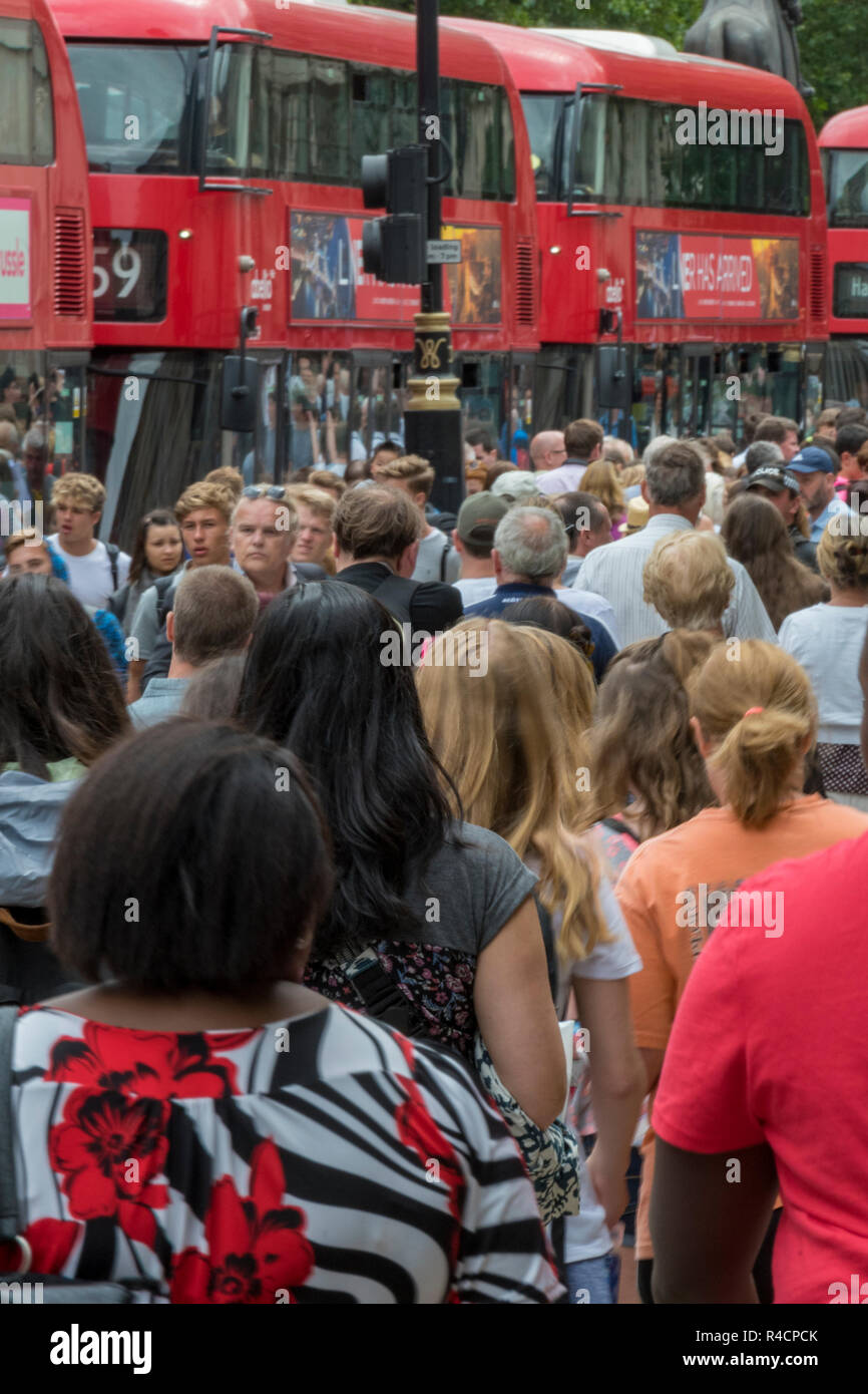 Einer belebten Straße im Zentrum von London mit Menschenmassen und London Transport rote Busse. Stockfoto