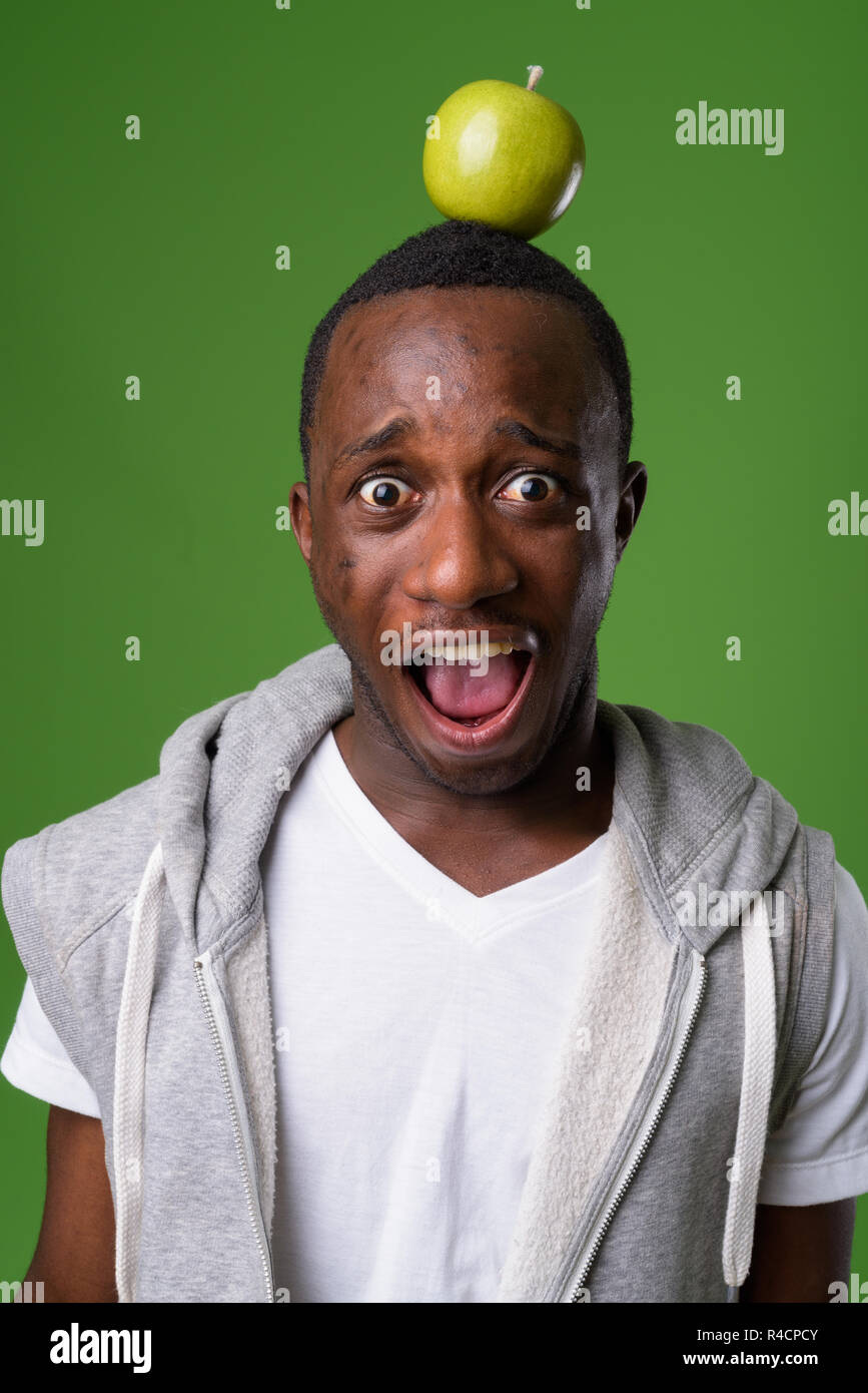Studio shot junger afrikanischer Mann gegen grüner Hintergrund Stockfoto