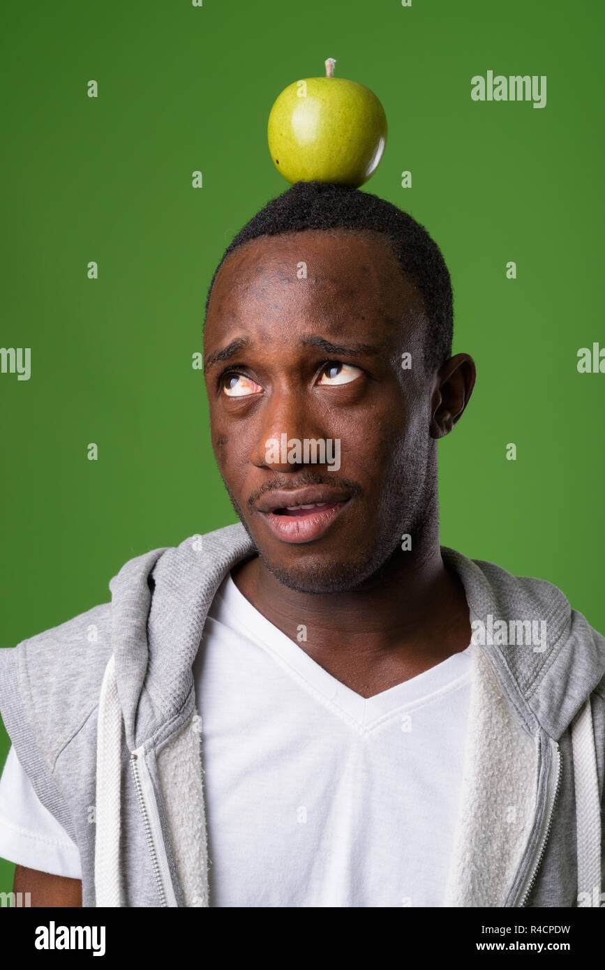 Studio shot junger afrikanischer Mann gegen grüner Hintergrund Stockfoto