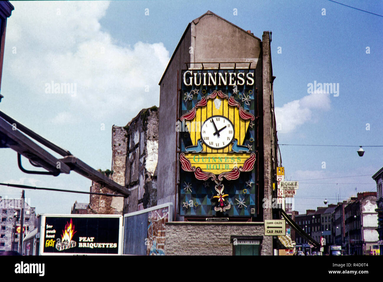 Guinness Werbung und die Uhr auf der Seite von Irwin Brüder Uhren und Schmuck Shop die 1897 bei 22 Patrick Street eröffnet, (R445), Limerick, County Limerick, Irland, eingesehen werden. Der Bereich neu erzeugt wurde, da dieses ursprüngliche Bild in den 1960er Jahren aber nach der Suche auf Google Maps der Shop sieht nun geschlossen. Stockfoto