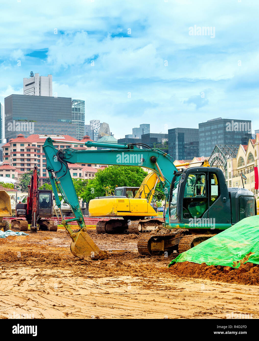 Bagger auf der Baustelle in Singapore Downtown, moderne Skyline im Hintergrund Stockfoto