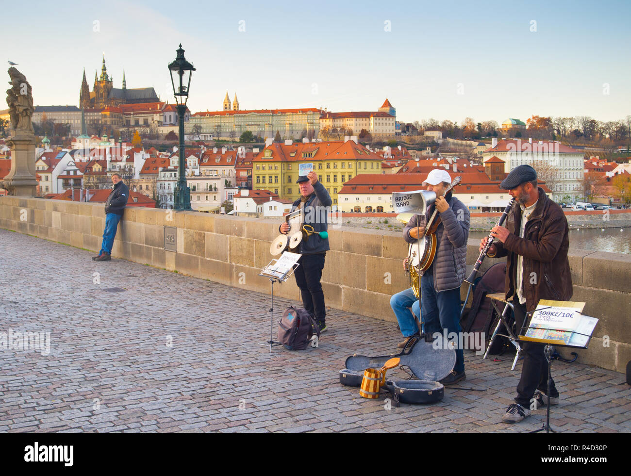 Prag, tschechische Republik - 14.November 2018: Street Music Band auf der Karlsbrücke in Prag. Die Prager Burg im Hintergrund. Stockfoto Prag, tschechische Republik - 14.November 2018: Street Music Band auf der Karlsbrücke in Prag. Die Prager Burg im Hintergrund. Stockfoto