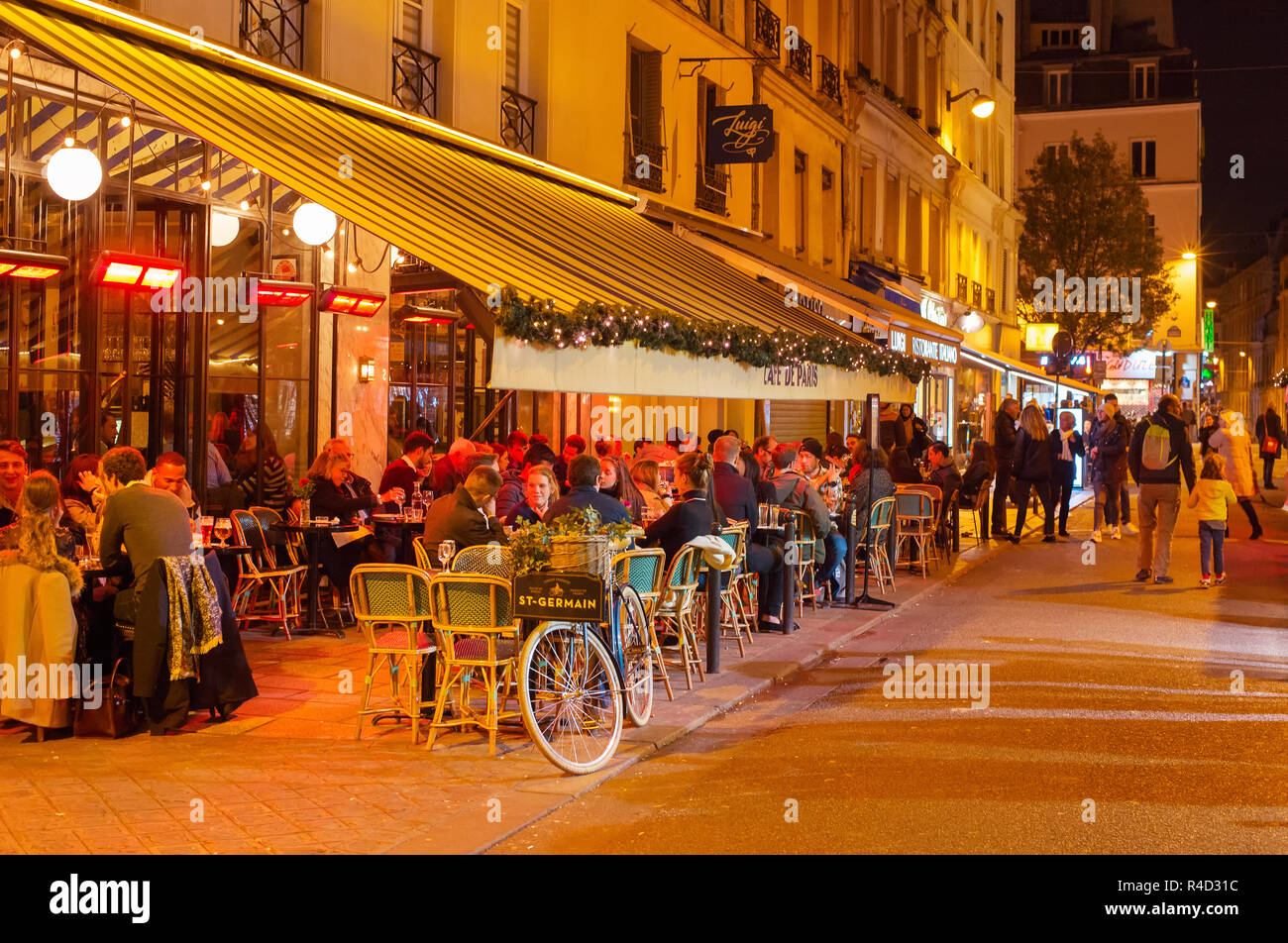 PARIS, FRANKREICH, November 09, 2018: Die Menschen in einem Street Restaurant in Paris bei Nacht. Paris ist die meistbesuchte Stadt in Europa Stockfoto